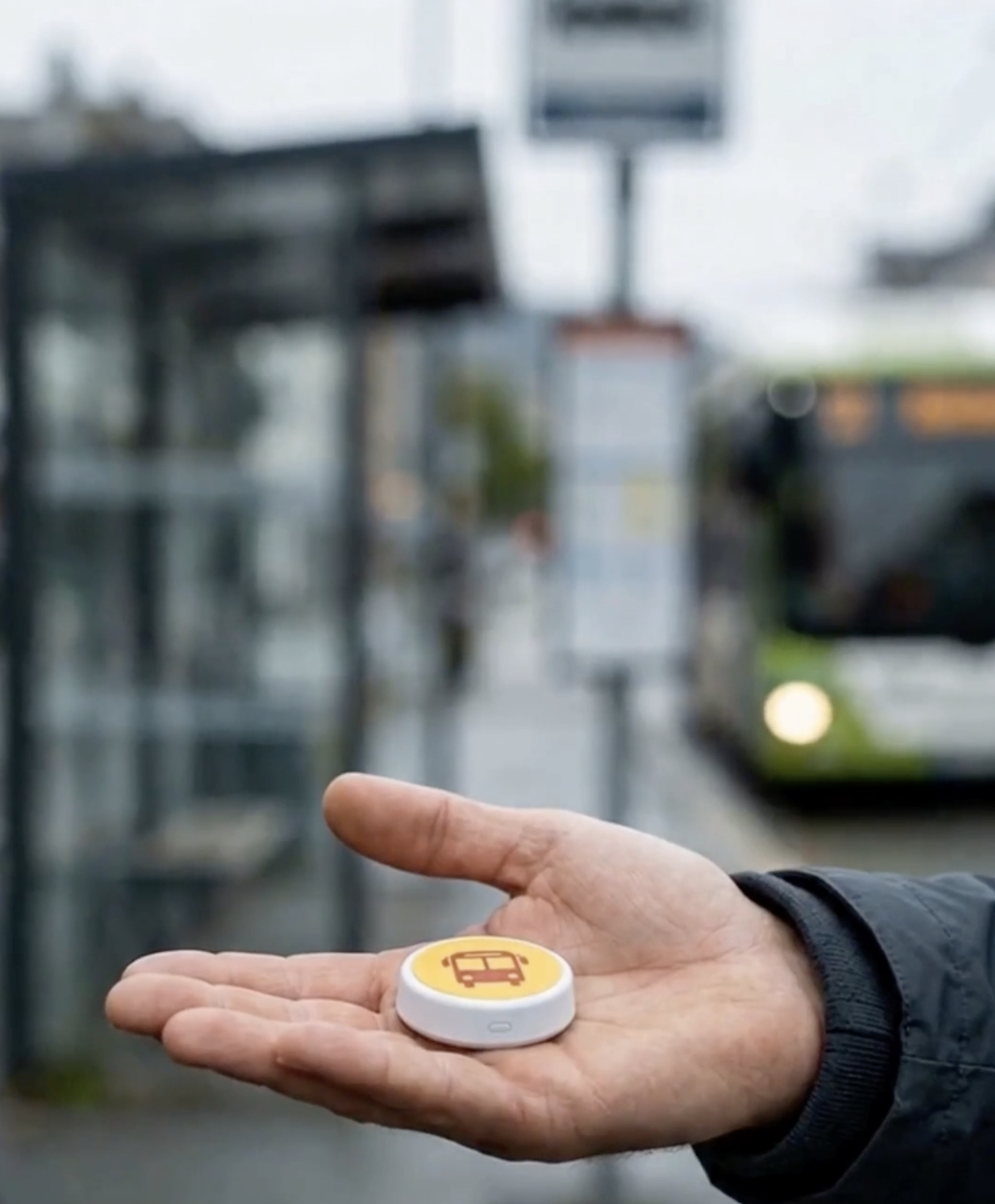 Den fysiske Bussenmin-knappen i en hånd ved en bussholdeplass